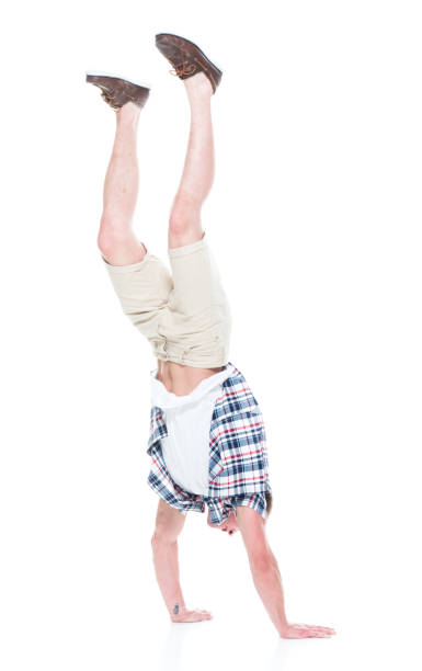 istock Handsome man in shirt and shorts is doing a handstand 1134493236