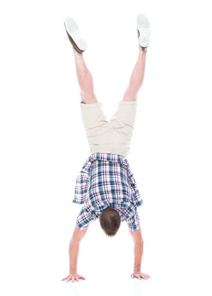 istock Handsome man in shirt and shorts is doing a handstand 1134493240