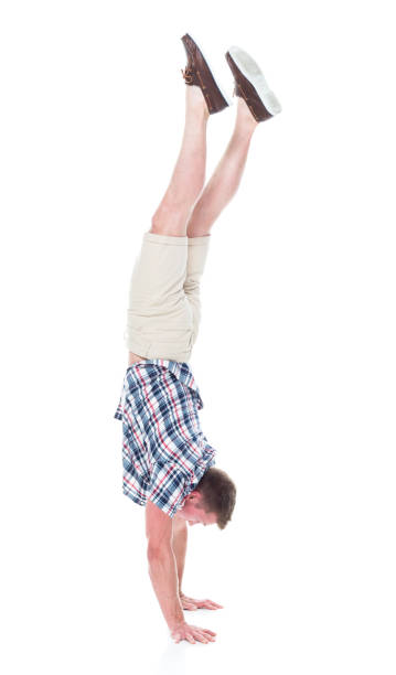 istock Handsome man in shirt and shorts is doing a handstand 1134493244