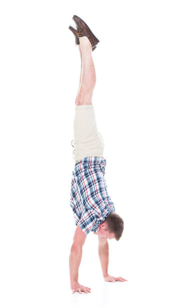 istock Handsome man in shirt and shorts is doing a handstand 1134493257