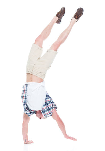 istock Handsome man in shirt and shorts is doing a handstand 1134493296