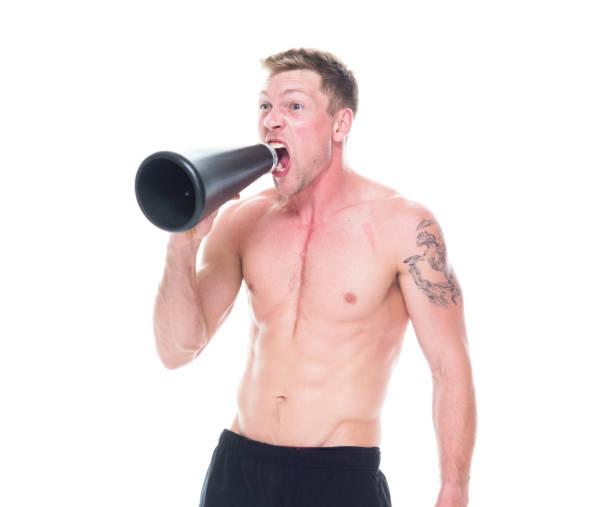 istock Handsome shirtless man is yelling into a megaphone 1134493932