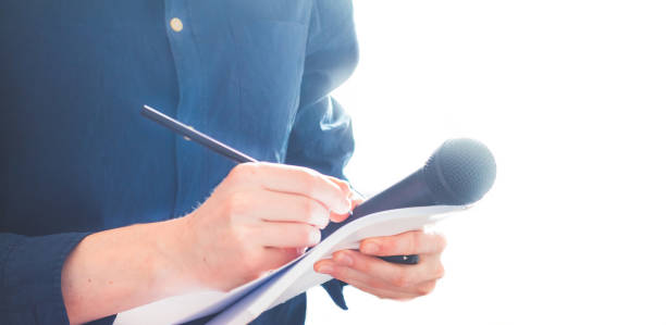 istock Male journalist at news conference, holding microphone and taking notes 1134494887