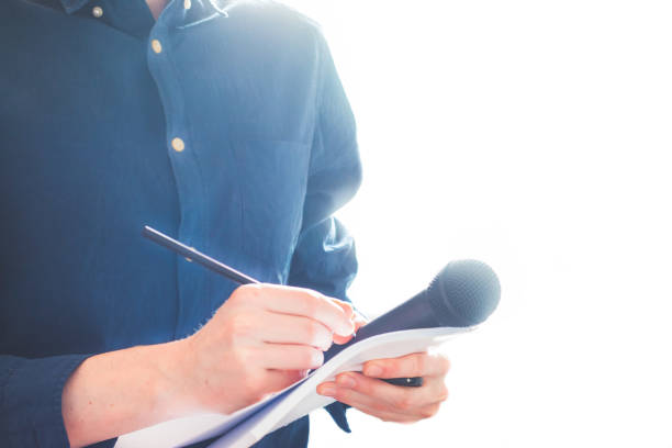istock Male journalist at news conference, holding microphone and taking notes 1134494979