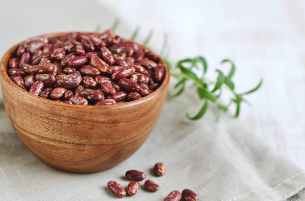 木のボウルに生の赤インゲン豆, ローズマリーハーブ - rosemary herb isolated ingredient ストックフォトと画像