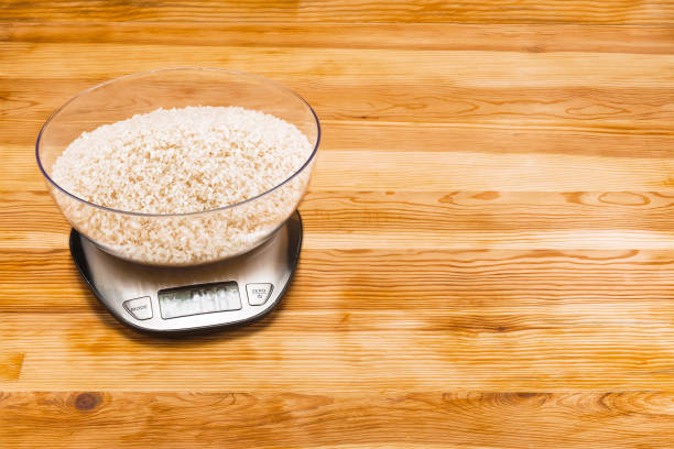 istock Rice in bowl on an electronic scale on a wood background with copy space 1134500368