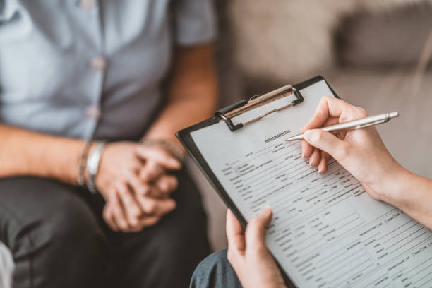 enfermera que escribe el informe médico para el paciente mayor en hogar del cuidado - clipboard note pad pen paper fotografías e imágenes de stock