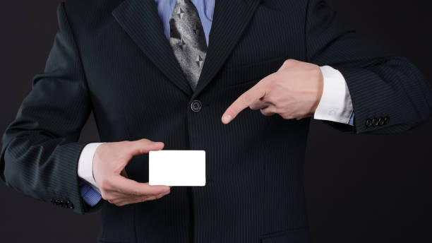 한 손으로 양복 지주 명함에 남자와 그의 검지 손가락으로 그녀를 가리키는 포인트 - index card holding paper men 뉴스 사진 이미지