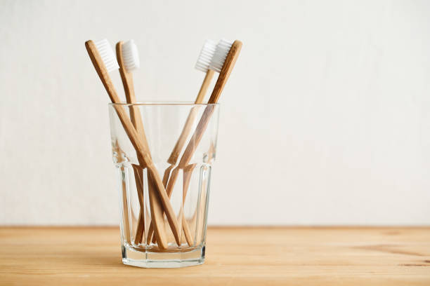 istock Four bamboo toothbrushes in a glass on a wooden table 1134508672