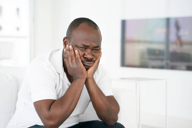 istock sad african man lies on the bed. 1134508858