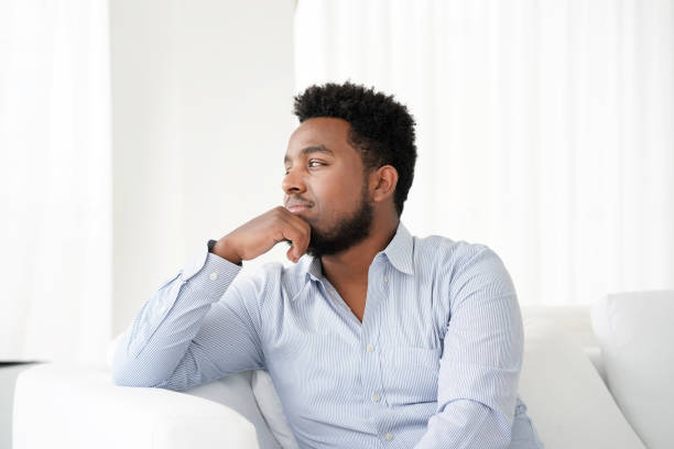 istock sad african man lies on the bed. 1134508937