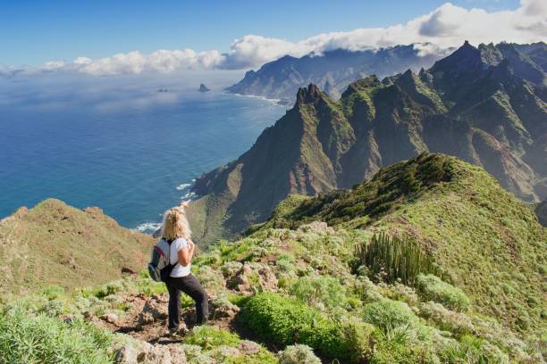 mujer excursionista viendo hermosos paisajes costales. -tenerife, islas canarias, españa. vista de la costa occidental, montaña anaga - pico de teide fotografías e imágenes de stock