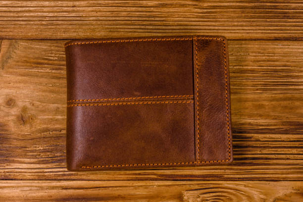 istock Closed brown leather wallet on wooden table. Top view 1134510227