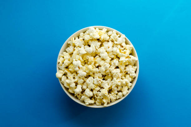 istock plate with popcorn on blue paper background 1134511339