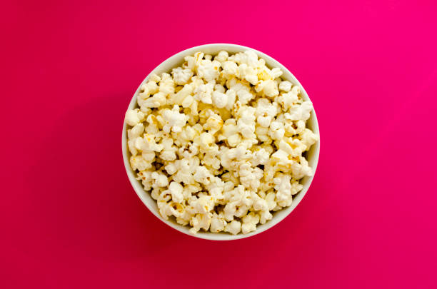istock plate with popcorn on pink paper background 1134511356