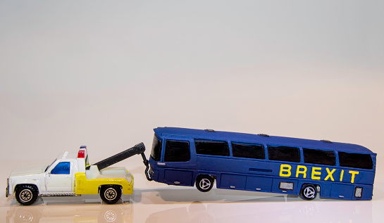Set of little white and green autobuses in miniature. Macro photograph of passenger coaches. Isolated on blue background