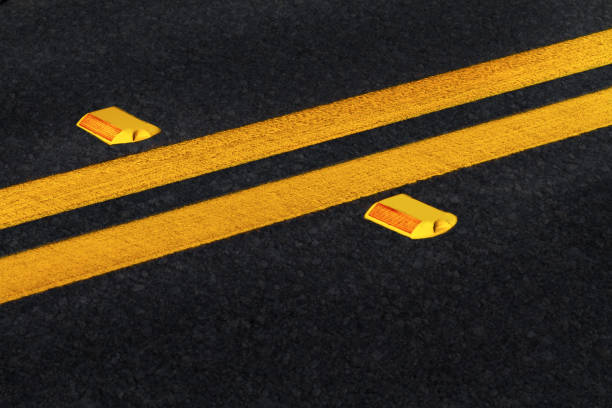 lignes jaunes doubles sur route asphaltée noire avec réflecteurs - road marking road reflector road dividing line photos et images de collection