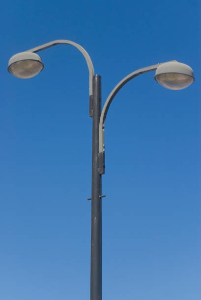 istock two grey street lamppost in blue sky 1134522150