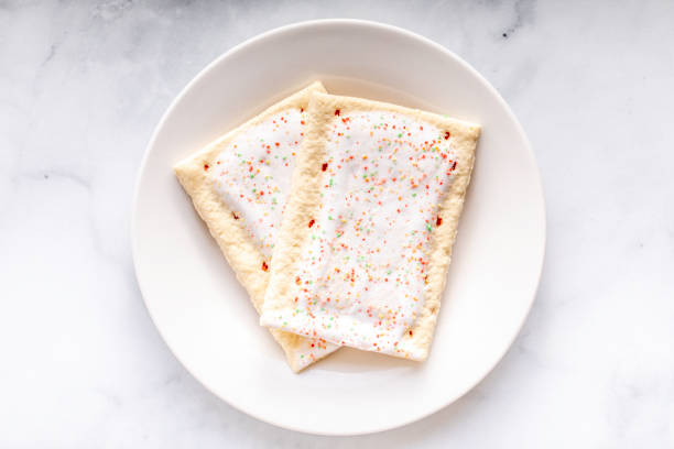 Toaster Pastries A toaster pastry with frosting, sprinkles, and red strawberry or cherry filling biscuit quick bread stock pictures, royalty-free photos & images