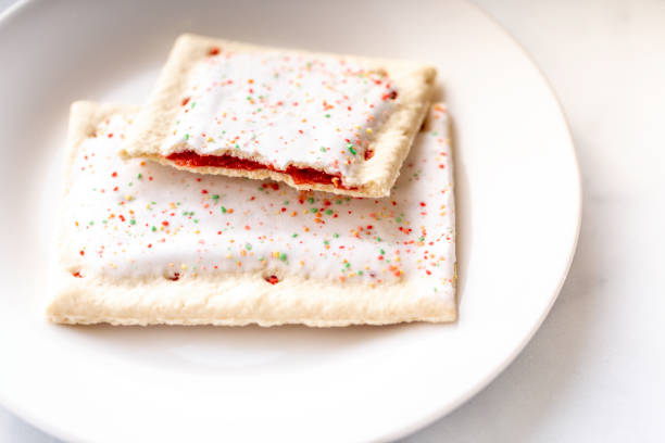 Toaster Pastries A toaster pastry with frosting, sprinkles, and red strawberry or cherry filling biscuit quick bread photos stock pictures, royalty-free photos & images