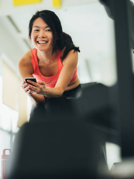 istock Young Asian woman using phone in gym 1134525299