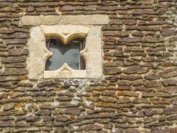 istock Closeup of ancient stone wall with an interesting square window. 1134526356