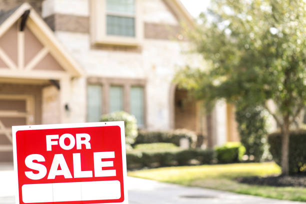 House for sale with real estate sign in yard. House for sale with "For Sale" real estate sign in yard in spring or summer season. No people. houses for sale stock pictures, royalty-free photos & images