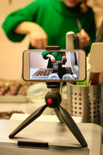 istock Woman in kitchen recording video on mobile phone 1134531288