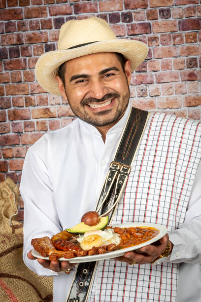 Colombian man holding a bandeja paisa (typical Colombian dish)