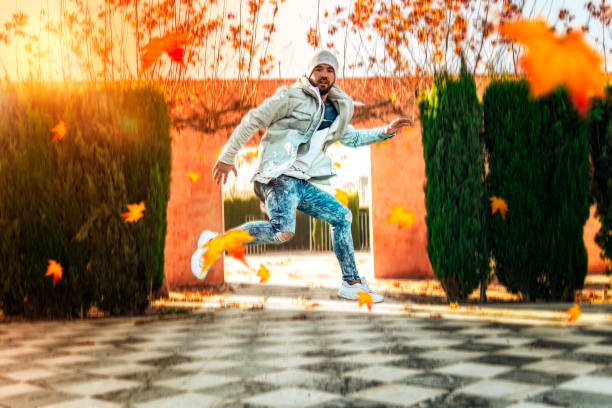 istock Man jumping in an autumn park with leaves falling 1134538154