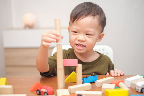 carino piccolo asiatico 2 - 3 anni bambino bambino che si diverte a giocare con giocattoli in legno blocco edificio al coperto - 2 3 years immagine foto e immagini stock