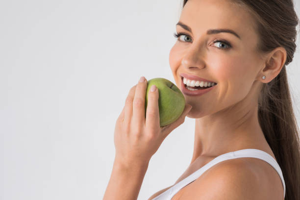 donna che morde la mela verde - apple women green eating foto e immagini stock