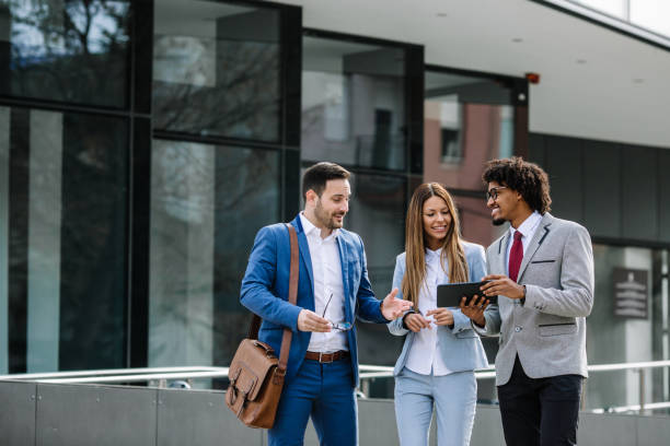 istock Smiling business colleagues walking outdoors and discussing. 1134559279