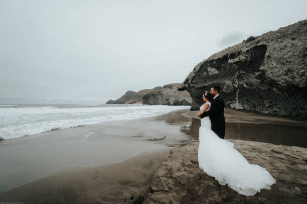 istock The bride and groom are walking along the beach. Panoramic view. 1134561126