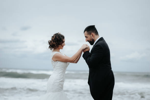istock The bride and groom are walking along the beach. Panoramic view. 1134561129