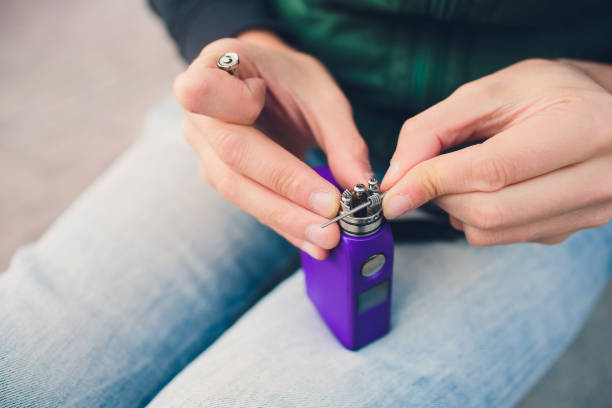 istock Maintenance of electronic mech mod vaping device.Modern vaporizer e-cig gadget to vape glycerin e-liquid.Vaper device repair service.Master replace wire for smoking.Ecig rapairing process. 1134562482