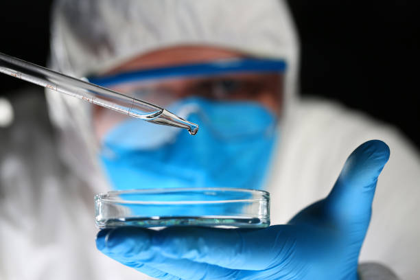 männlicher chemiker blick auf mikroskop-halteprüfstand - nahrungsmittelzusatz stock-fotos und bilder