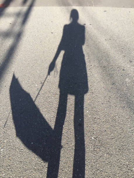 istock Shadow of a women holding an umbrella 1134565456