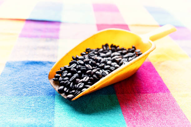 a dark and light roast of fresh whole coffee beans in colorful scoops on a festive table cloth in Mexico