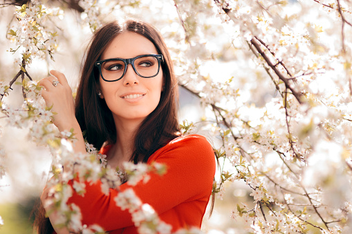Portrait of a Woman Wearing Eyeglasses under Blooming Tree