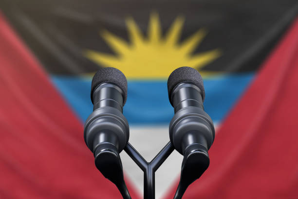 istock Antigua and Barbuda flag with microphones and a podium 1134585185