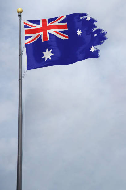 istock Worn and tattered Australia flag blowing in the wind on a cloudy day 1134585262
