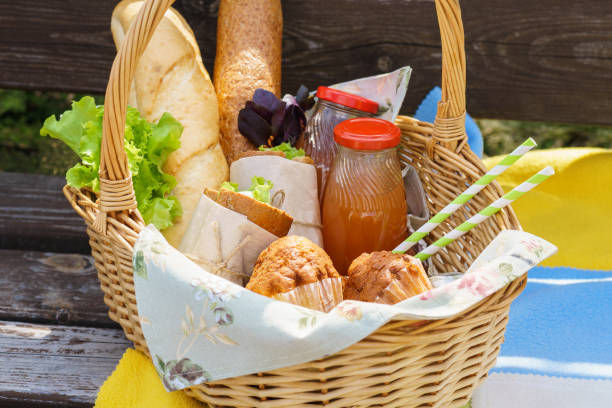 istock Picnic basket with food and drinks on a park bench for lunch. 1134586065
