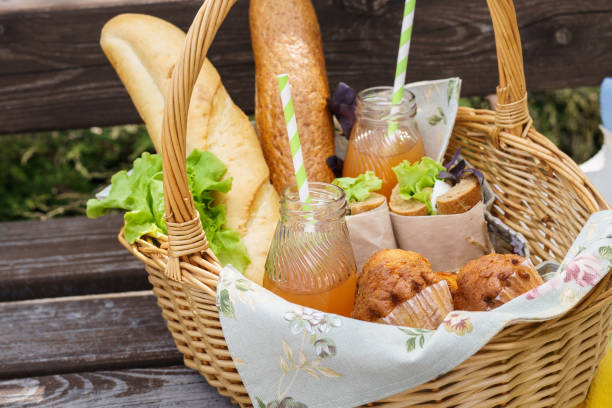 istock Picnic basket with food and drinks on a park bench for lunch. 1134586103