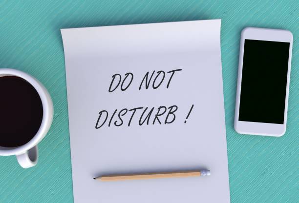 istock DO NOT DISTURB, message on paper, smart phone and coffee on table, 3D rendering 1134589685