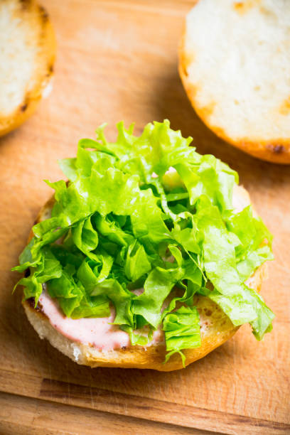 istock Making burger with fresh buns, meat and salad 1134591741