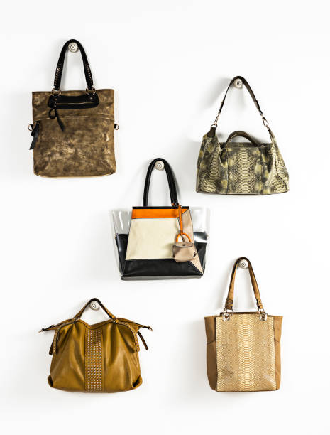 istock Fashionable handbags hanging on white background 1134592725