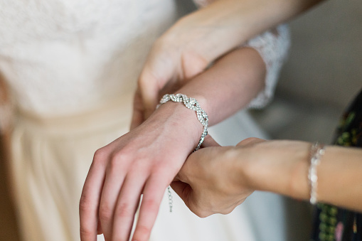 bride putting on luxury bracelet on hand in the morning, getting ready
