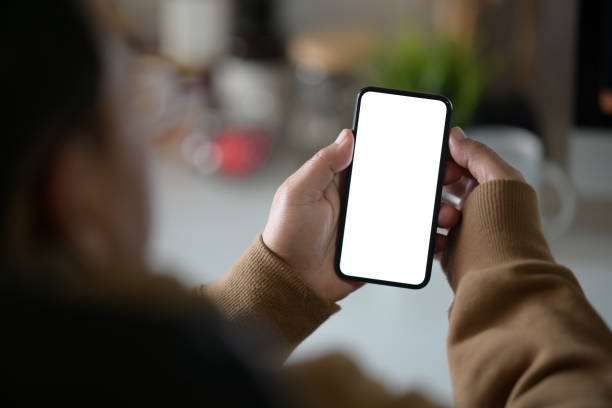 istock Male hand with a black mobile phone with white blank screen 1134599345