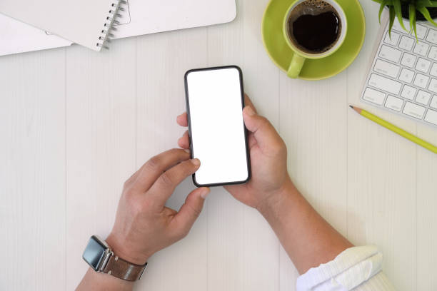 istock Businessman holding mobile phone on office desk 1134600161